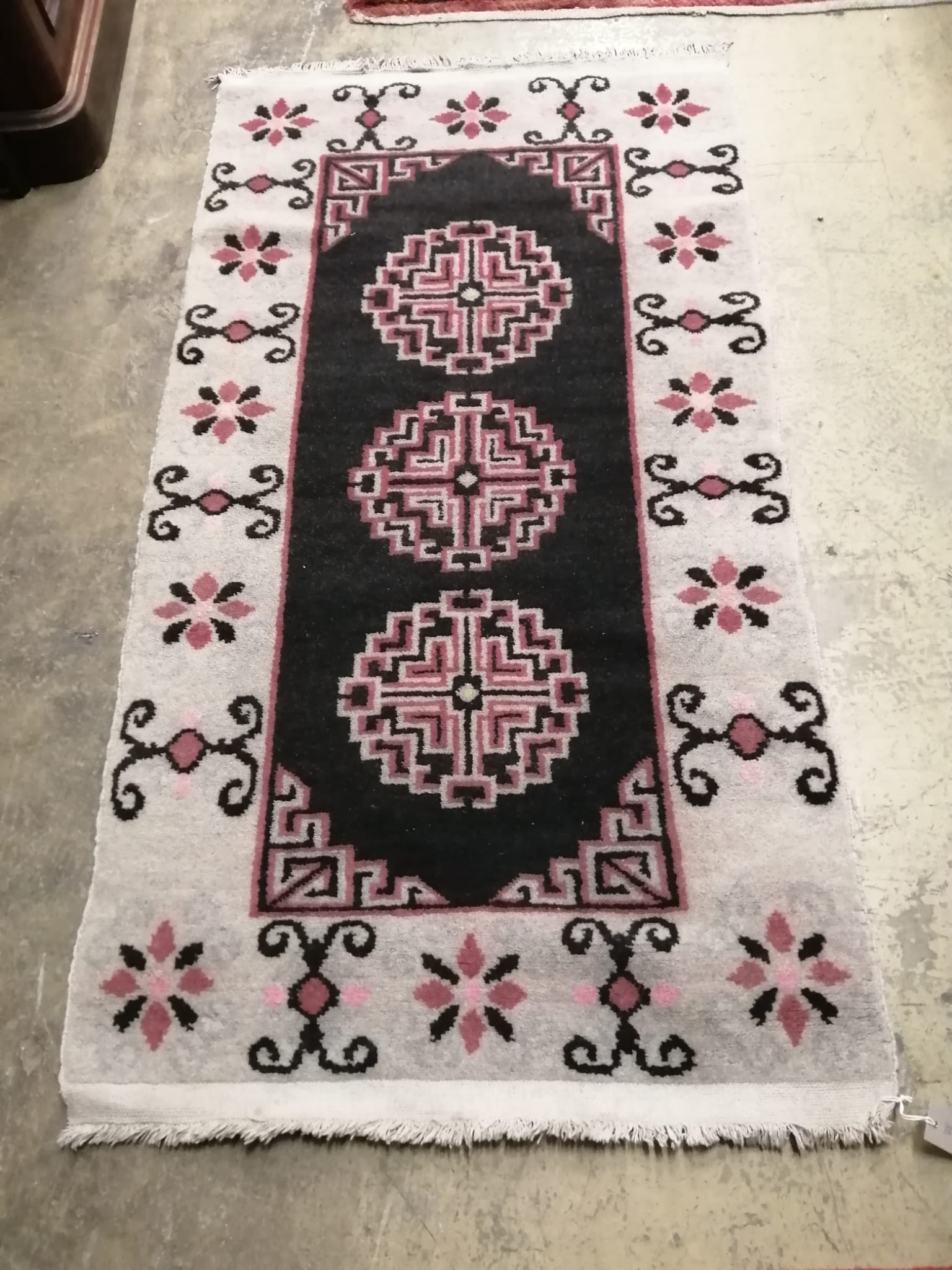 A Tibetan black ground geometric rug, 164cm x 86cm